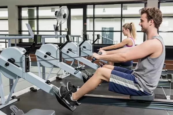 people at gym working out on different types of rowing machines