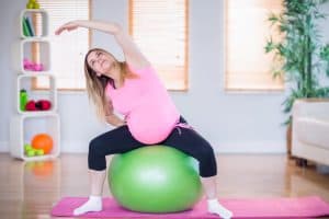 pregnant stretching on a fit ball