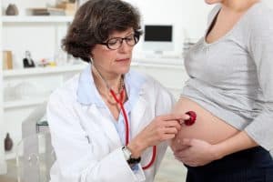 doctor checking baby on pregnant lady