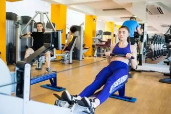 lady wearing blue outfit exercising on a Rower
