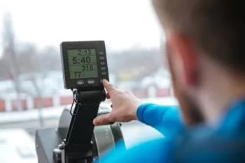 man working out on concept 2 monitor how long it should take to row 100 meters