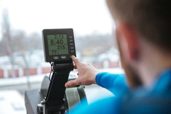 man using concept2 rower increasing intensity to faster for a harder sprint