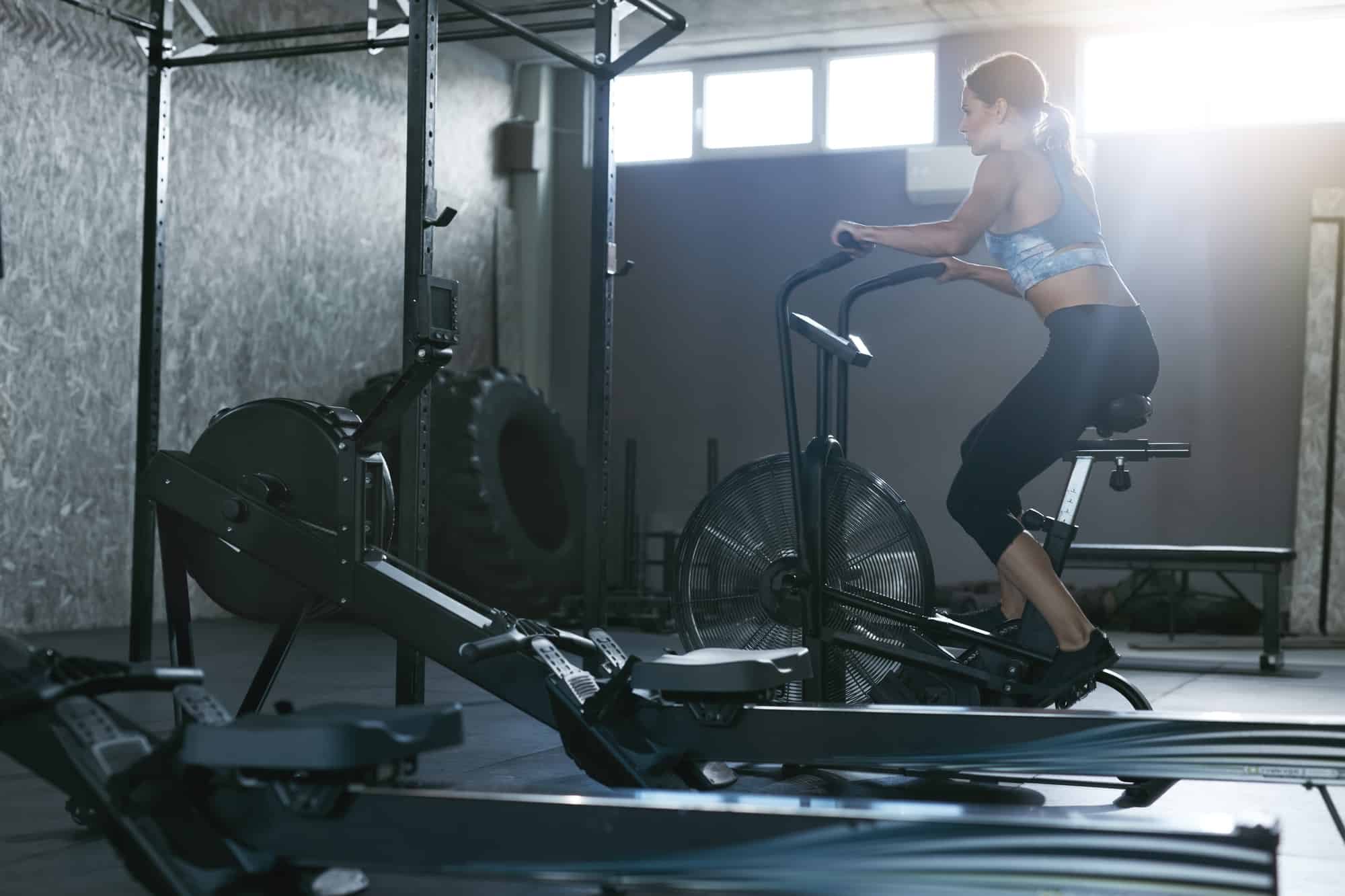 lady at gym working out on an assault bike crossfit 