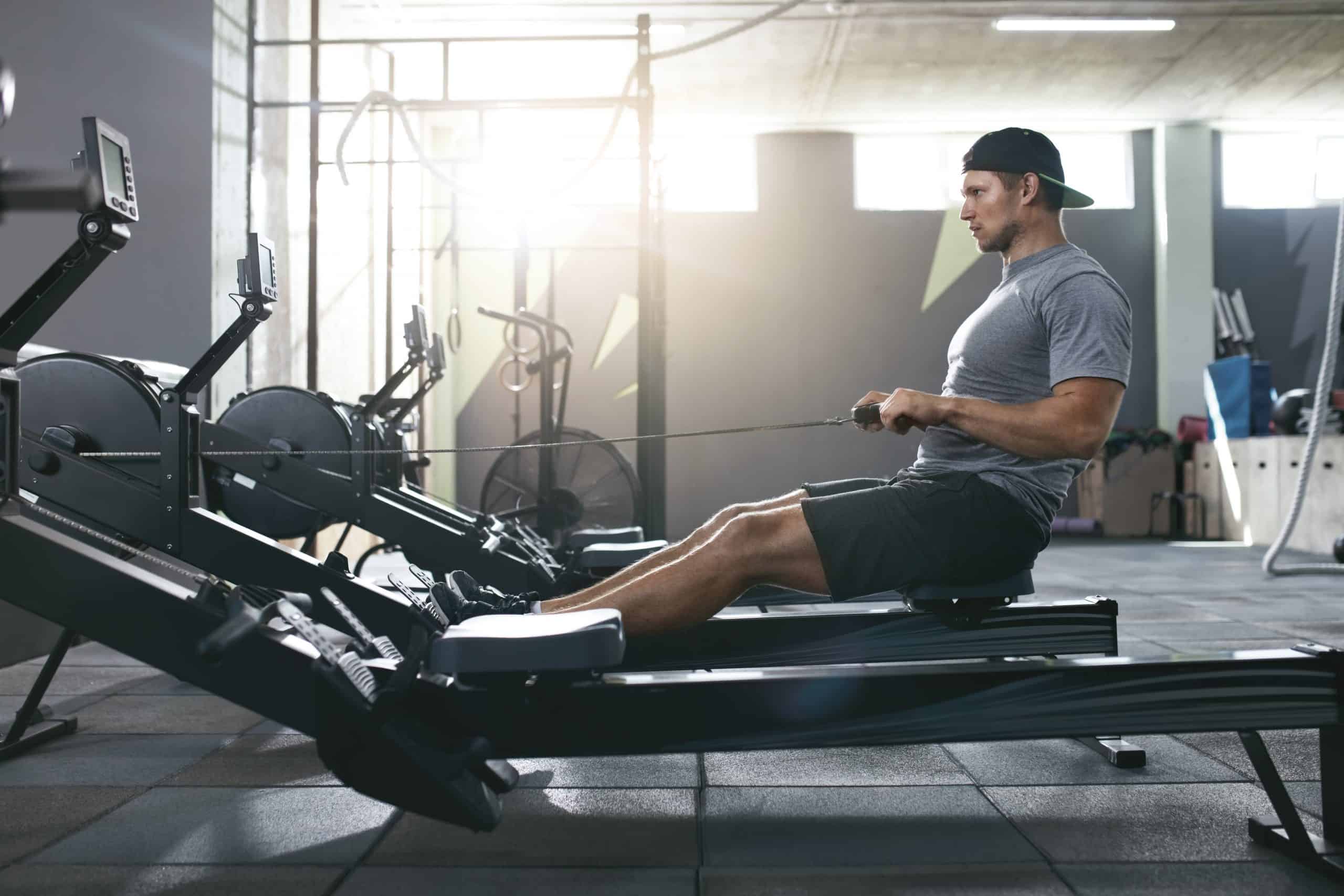 young man using crossfit machines in his workout class