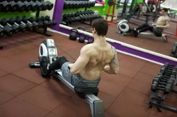 man showing how to exercise correctly to prevent lower back pain on a rowing machine