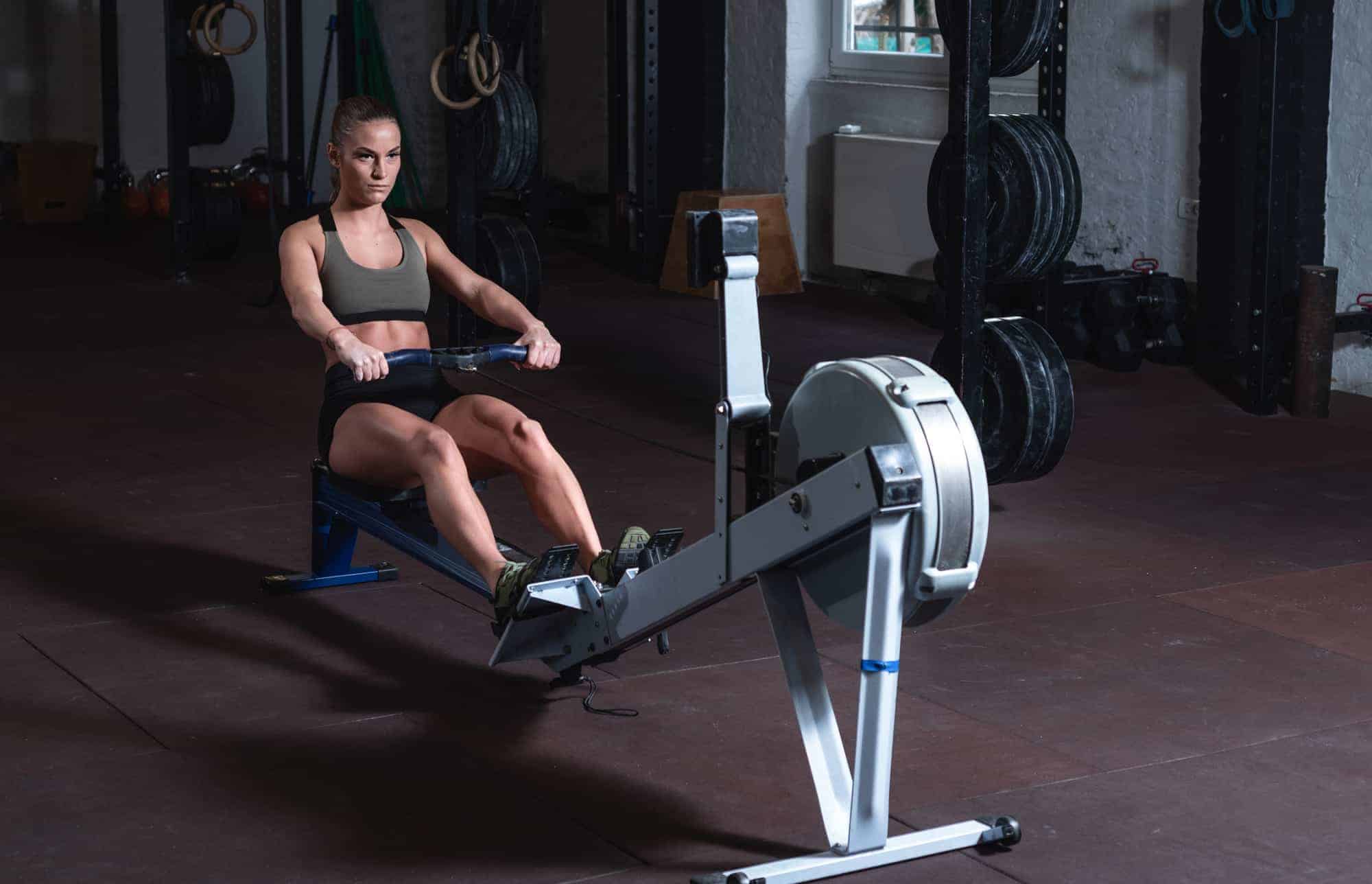 lady reading monitor on machine to see how many calories burned rowing