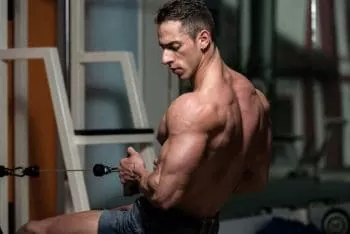 Man flexing arms while exercising with indoor rower