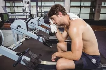 man resting after work out wiping sweat from head