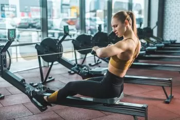 lady toning arms on a rowing machine at the gym