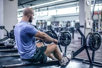 man wearing a blue shirt doing rowing exercise