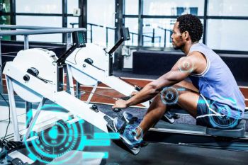 man using a rowing machine at the gym