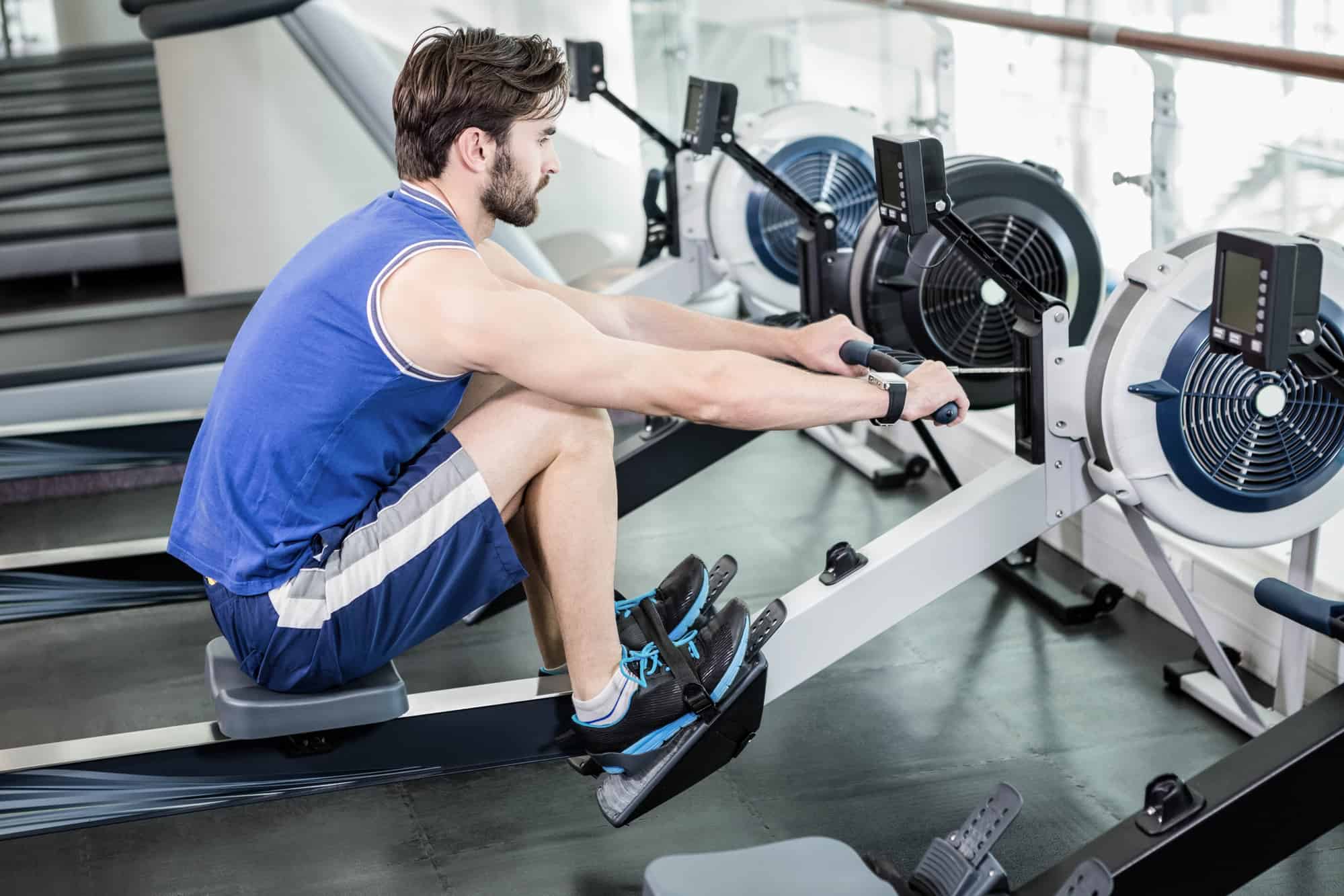 low impact exercise machines at the gym with a man working out in a blue shirt