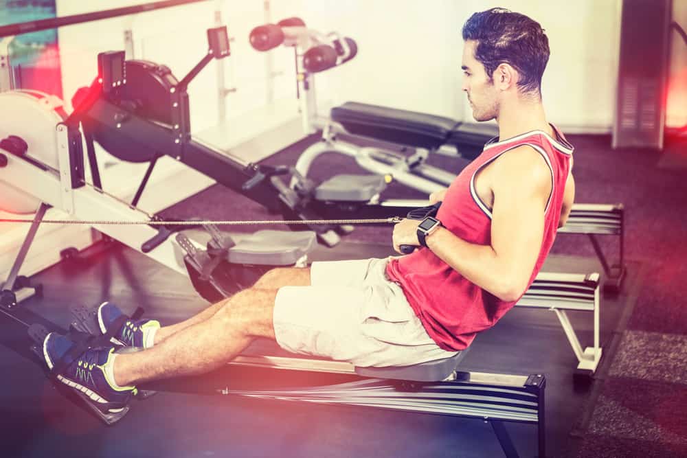 man at gym safely rowing after a hip replacement 