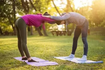 two woman doing body stretching