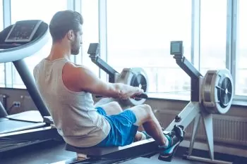 man working out on a rower trying to increase his fitness
