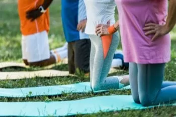 group of people doing exercise holding their hips