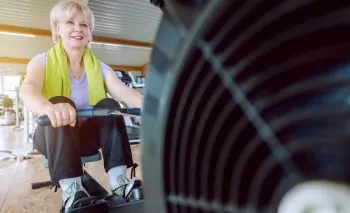 Senior woman on the rowing machine in a fitness gym