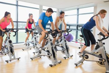 Indoor spin class at local gym doing an intense workout 