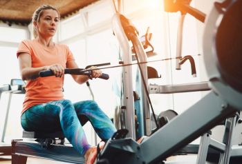 lady working out at gym to see are rowers good exercise