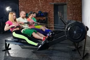 people at gym working out on commercial rowers