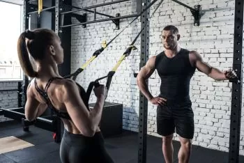 lady learning how to use bands at the gym with trainer 