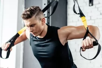 man working out doing rowing exercise with bands 