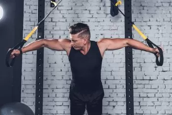 man showing rowing at home with bands for arm strength