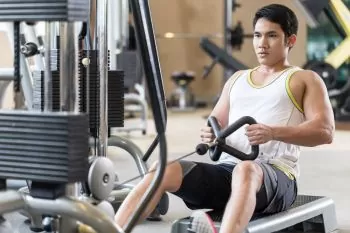 man learning a beginners rowing technique at the gym