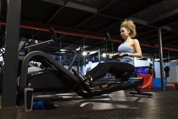 lady training at gym do a rowing machine fat loss program 