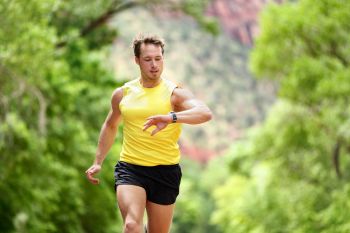 man checking heart rate monitor while jogging