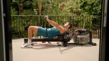 Man rowing outside on a rower with resistance training system 