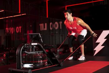 man using lit method water rower with resistance bands