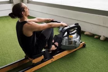 sportsman training on a water rowing machine