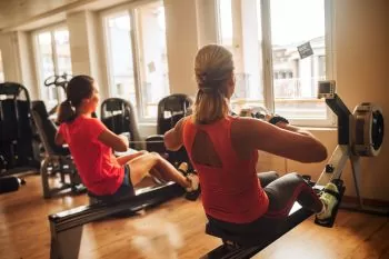 Two ladies working out using rowing machines