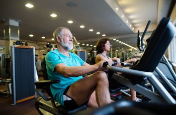 elderly man rowing at the gym