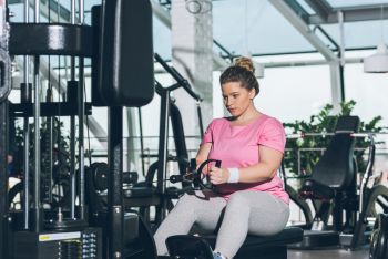 female rower training at gym in pink shirt