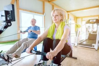 couple at the age of 50 rowing together at home