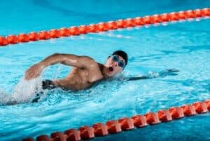 man swimming training in a pool for rowing cross-training 