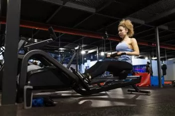 blonde woman working out in a rowing machine