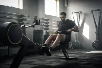man doing strength training on a rowing machine
