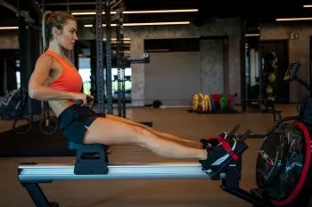 lady at gym improving her split time rowing