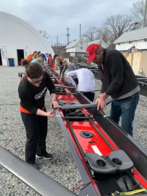 team of rowers getting their boat ready for a race