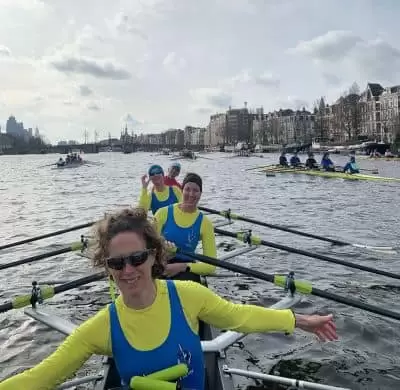 ladies posing for photo by their rowing coach for masters rowing