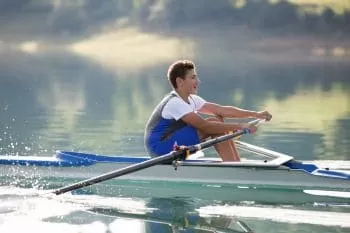 Young boy rowing on the river