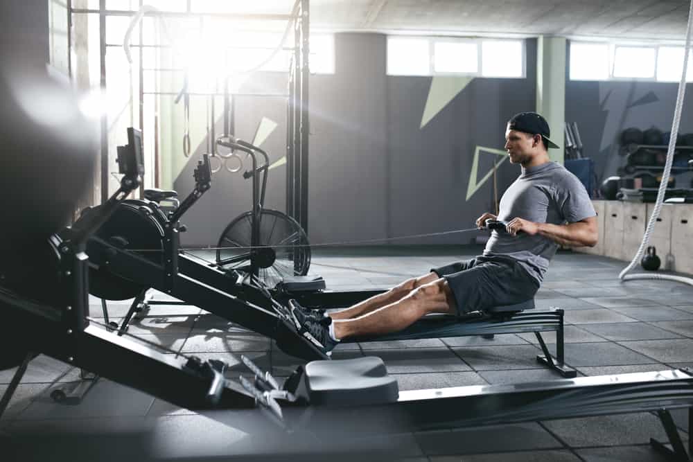 man at gym trying resistance training on a rowing machine
