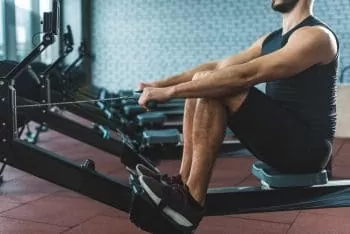 man at gym doing rowing machine strength training