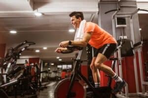 man exercising on a spin bike as part of his cross training program