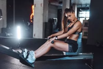 lady working out on a rower with rowing seat pad