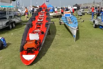 red rowing shell sitting on the grass