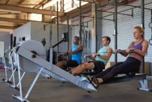 3 people rowing at gym